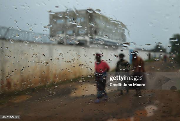 People walk past the Island Clinic Ebola treatment center on October 13, 2014 in Monrovia, Liberia. A planned strike was averted as most nurses and...