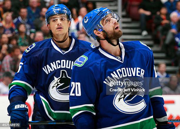 Luca Sbisa and Chris Higgins of the Vancouver Canucks skate to the bench during their NHL game against the Edmonton Oilers at Rogers Arena October...