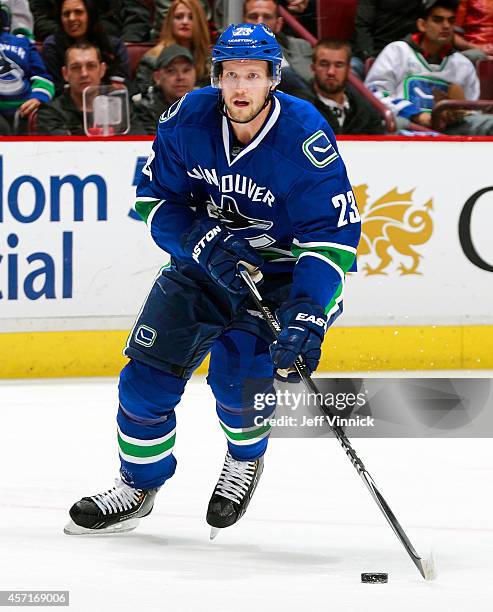 Alexander Edler of the Vancouver Canucks skates up ice with the puck during their NHL game against the Edmonton Oilers at Rogers Arena October 11,...