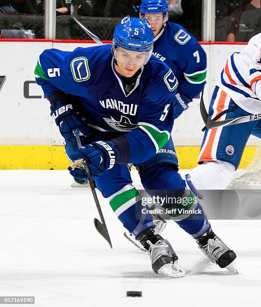 Luca Sbisa of the Vancouver Canucks skates up ice with the puck during their NHL game against the Edmonton Oilers at Rogers Arena October 11, 2014 in...