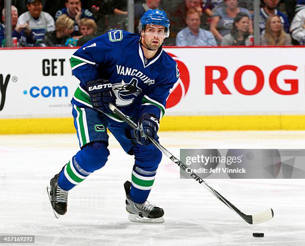 Dan Hamhuis of the Vancouver Canucks skates up ice with the puck during their NHL game against the Edmonton Oilers at Rogers Arena October 11, 2014...