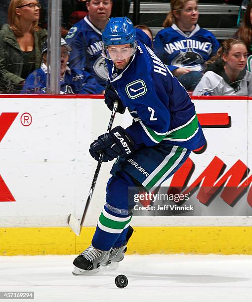 Dan Hamhuis of the Vancouver Canucks skates up ice with the puck during their NHL game against the Edmonton Oilers at Rogers Arena October 11, 2014...