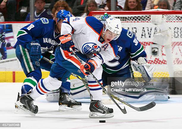 Taylor Hall of the Edmonton Oilers looks for a loose puck during their NHL game against the Vancouver Canucks at Rogers Arena October 11, 2014 in...