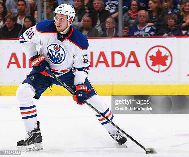 Nikita Nikitin of the Edmonton Oilers skates up ice with the puck during their NHL game against the Vancouver Canucks at Rogers Arena October 11,...