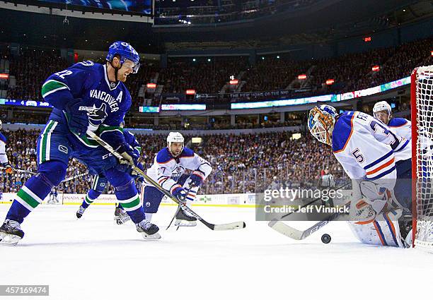 Viktor Fasth of the Edmonton Oilers makes a save off the shot of Daniel Sedin of the Vancouver Canucks during their NHL game at Rogers Arena October...