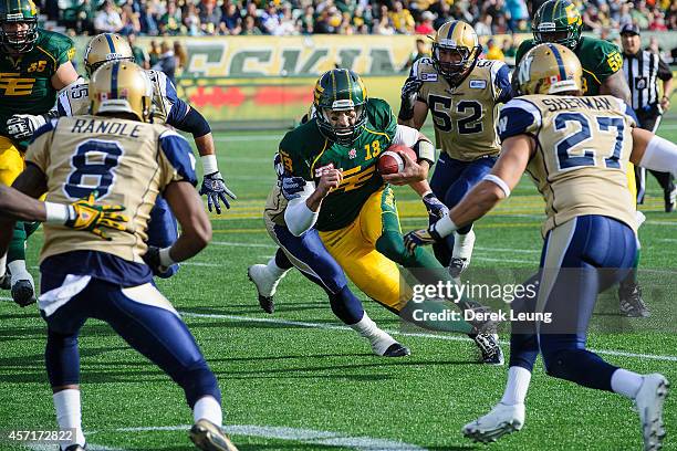 Mike Reilly of the Edmonton Eskimos runs with the ball against the Winnipeg Blue Bombers during a CFL game at Commonwealth Stadium on October 13,...