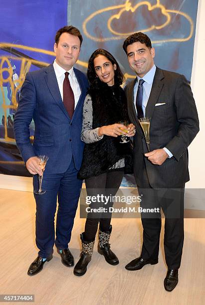 Matt Langton, Karima Burman and Guarav Burman attend the launch party for Phillips European Headquarters at 30 Berkeley Square on October 13, 2014 in...