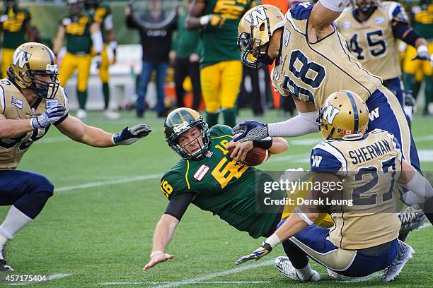 Matt Nichols of the Edmonton Eskimos is tackled by the Winnipeg Blue Bombers after running the ball during a CFL game at Commonwealth Stadium on...