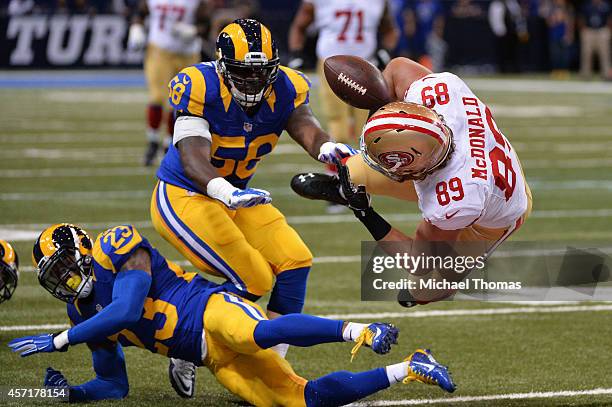 Vance McDonald of the San Francisco 49ers fumbles the ball as he is tackled by Rodney McLeod and Jo-Lonn Dunbar of the St. Louis Rams in the first...