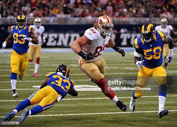 Vance McDonald of the San Francisco 49ers avoids the tackle of E.J. Gaines of the St. Louis Rams before he fumbles the ball as he is tackled by...