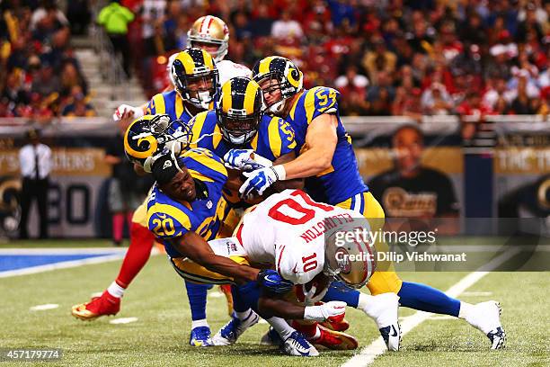 Lamarcus Joyner of the St. Louis Rams looses his helmet as he tackles Bruce Ellington of the San Francisco 49ers in the second quarter at Edward...