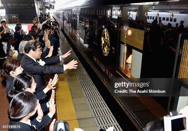 Kyushu's luxury sleeper cruise train 'Nanatsuboshi' departs while staffs wave during the first anniversary ceremony of its launch at Hakata Station...