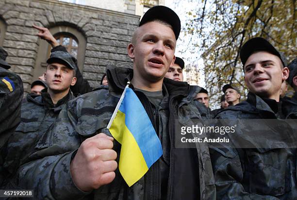 Soldier of Ukrainian National Guard holds Ukraine flag during a demonstration outside of the presidential administration office in Kiev, Ukraine on...