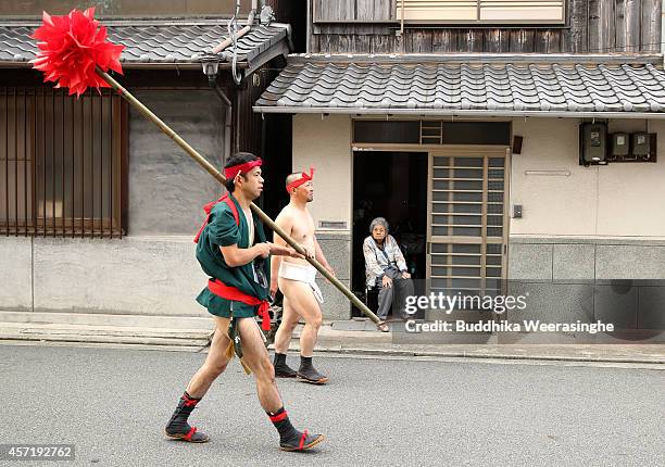 Japanese Shrine Parishioners of Matsubara team wears Fundoshi or loincloths as they walk past an elderly woman during the first day of the Nada...