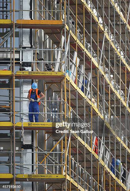 Workers stand on scaffolding at a construction site on October 14, 2014 in Berlin, Germany. Germany Economy Minister Sigmar Gabriel is scheduled...