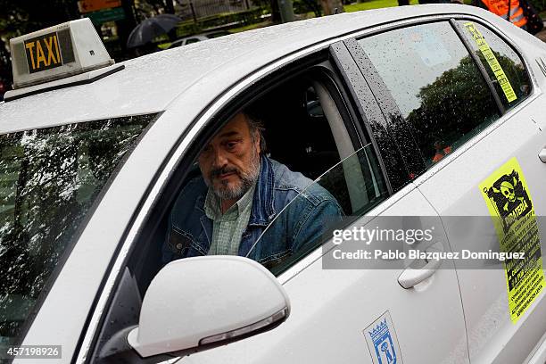 Taxi driver drives his car during a protest against new private cab 'UBER' application on October 14, 2014 in Madrid, Spain. 'Uber' application...