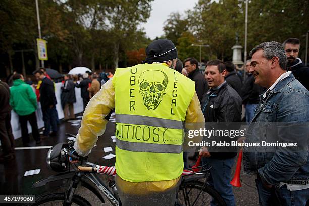 Taxi driver wears a jacket reading 'UBER Illegal. Politicians.' during a protest against new private cab 'UBER' application on October 14, 2014 in...