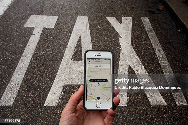 In this photo illustration the new smart phone taxi app 'Uber' shows how to select a pick up location next to a taxi lane on October 14, 2014 in...