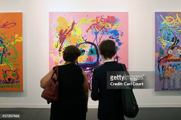 Visitors view paintings and installation pieces by artist Mark Hagen during the VIP and press day at the Frieze Art Fesival on October 14, 2014 in...