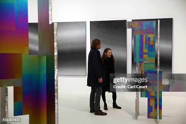 Visitors view paintings and installation pieces by artist Mark Hagen during the VIP and press day at the Frieze Art Fesival on October 14, 2014 in...