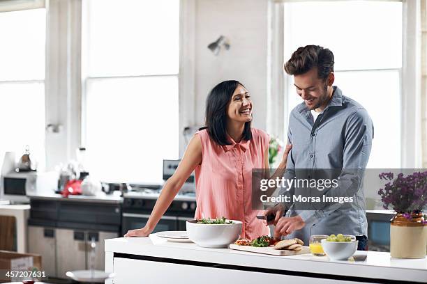 couple preparing food in kitchen - food on cutting board stock pictures, royalty-free photos & images