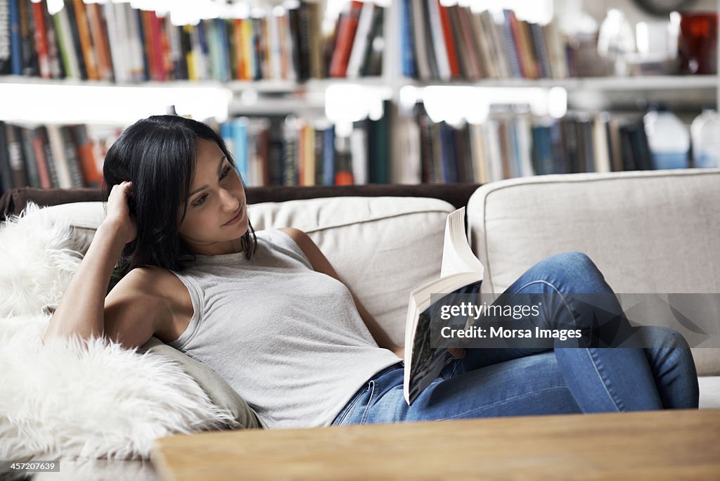 Woman relaxing on sofa reading a book