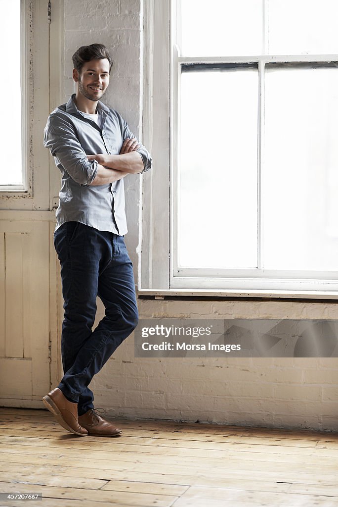 Portrait of man standing by window