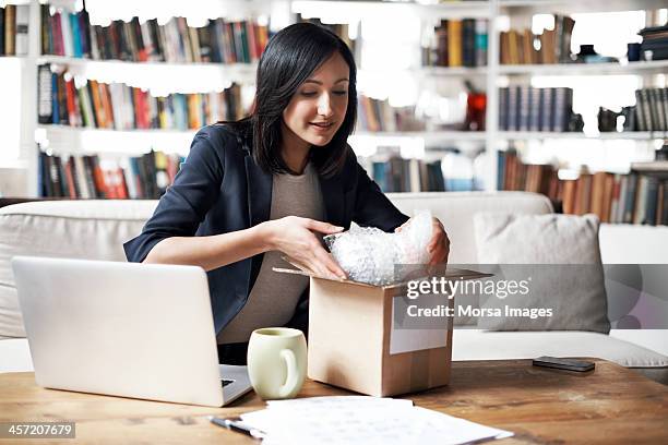 woman preparing parcel for shipment - packaging foto e immagini stock