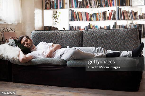 man sleeping on sofa - sleeping man stock pictures, royalty-free photos & images