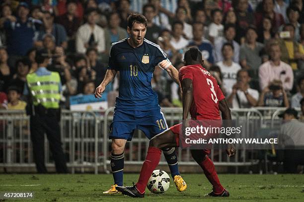 Argentina striker Lionel Messi and Hong Kong player Agbo Wisdom Fofo vie for the ball during their international friendly football match in Hong Kong...