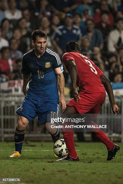 Argentina striker Lionel Messi and Hong Kong player Agbo Wisdom Fofo vie for the ball during their international friendly football match in Hong Kong...