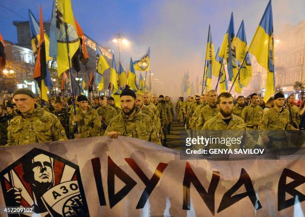 Ukrainian nationalists and servicemen of the Azov battalion demonstrate in Kiev on October 14, 2014 to mark the founding of the Ukrainian Insurgent...