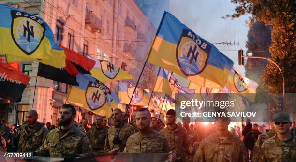 Ukrainian nationalists and servicemen of the Azov battalion demonstrate in Kiev on October 14, 2014 to mark the founding of the Ukrainian Insurgent...