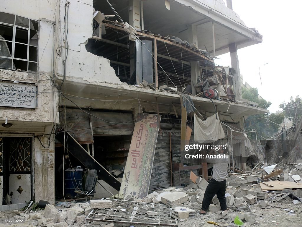 Syrians check the debris of the buildings, destroyed by the Government's air strike