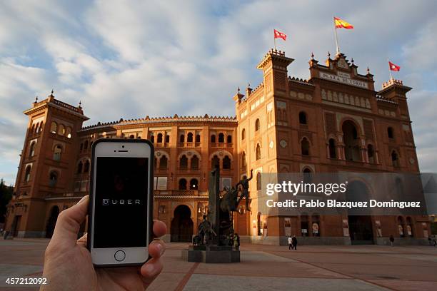 In this Photo Illustration a smart phone displays a picture with the logo of the news taxi app 'Uber' outside Plaza de Toros Las Ventas on October...