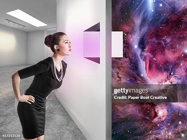 woman looking through a window to another universe - bend over woman stock pictures, royalty-free photos & images