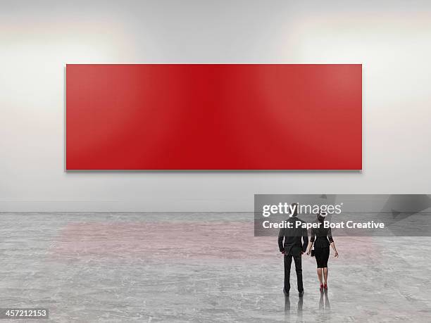 business people looking at giant red art canvas - business people looking at giant red art canvas stock-fotos und bilder