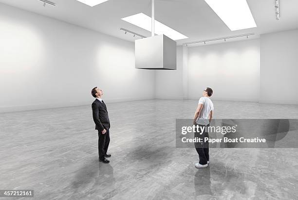 casual man and business man looking at blank cube - man stand stockfoto's en -beelden