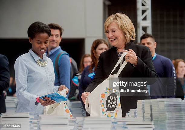 Hillary Clinton, former U.S. Secretary of state, right, helps fill tote bags with items for new parents during the DreamForce Conference in San...