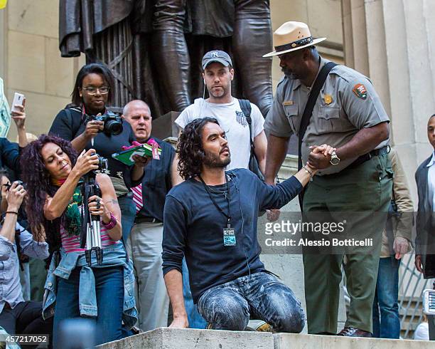 Russell Brand joins the Occupy Wall Street crowd at Zuccotti Park to promote his book 'Revolution' on October 14, 2014 in New York City.