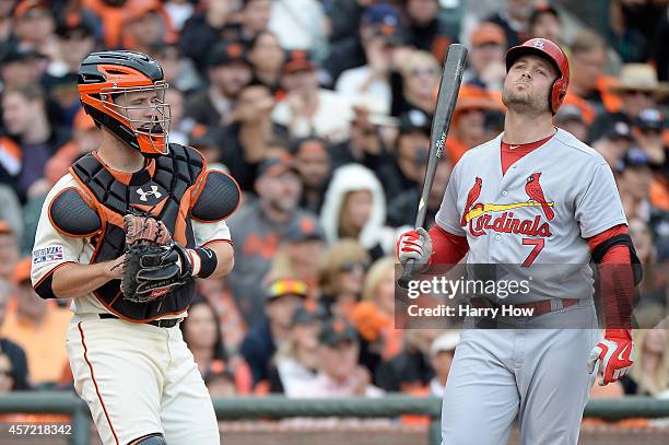 Matt Holliday of the St. Louis Cardinals reacts to strike two alongside Buster Posey of the San Francisco Giants in the 10th inning during Game Three...