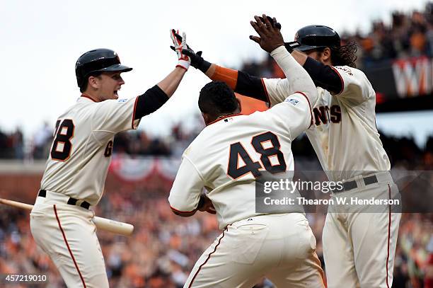 Brandon Crawford of the San Francisco Giants scores the game-winning run and celebrates with Pablo Sandoval and Buster Posey as the Giants defeat the...