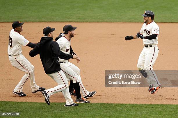 Gregor Blanco of the San Francisco Giants and the Giants celebrate the 10th inning 5-4 victory against the St. Louis Cardinals during Game Three of...