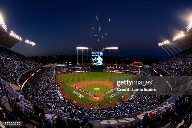 Fireworks explode overhead as the Baltimore Orioles and the Kansas City Royals stand on the baseline during the national anthem prior to Game Three...