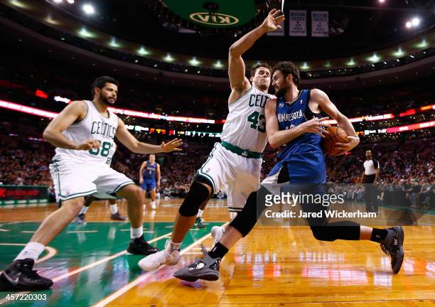 Kevin Love of the Minnesota Timberwolves attempts to drive the baseline in front of Kris Humphries and Vitor Faverani of the Boston Celtics in the...
