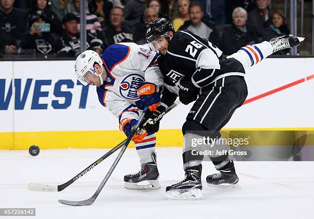 Justin Schultz of the Edmonton Oilers takes an off balance shot while defended by Slava Voynov of the Los Angeles Kings in the first period at...