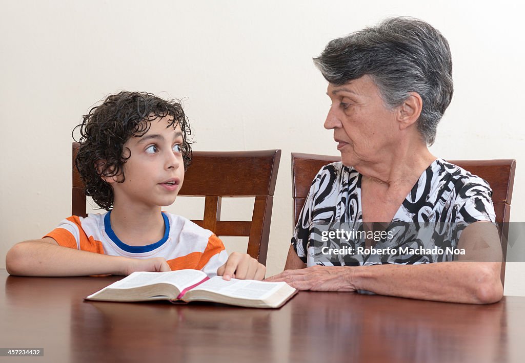 Grandmother teaching the Holy Bible to her grandson.