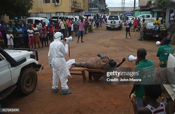 Aid workers from the Liberian Medical Renaissance League stage an Ebola awareness event on October 15, 2014 in Monrovia, Liberia. The group performs...