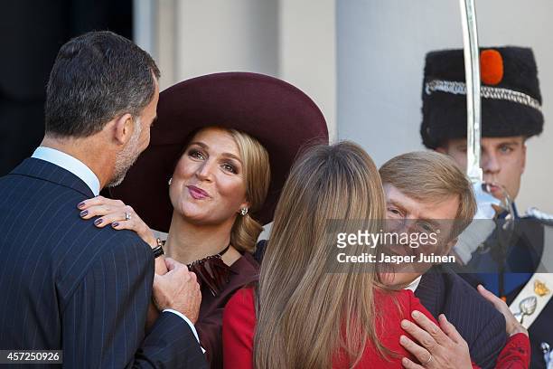 King Felipe VI of Spain holds Queen Maxima of the Netherlands by her wrist as Queen Letizia of Spain kisses King Willem-Alexander of the Netherlands...
