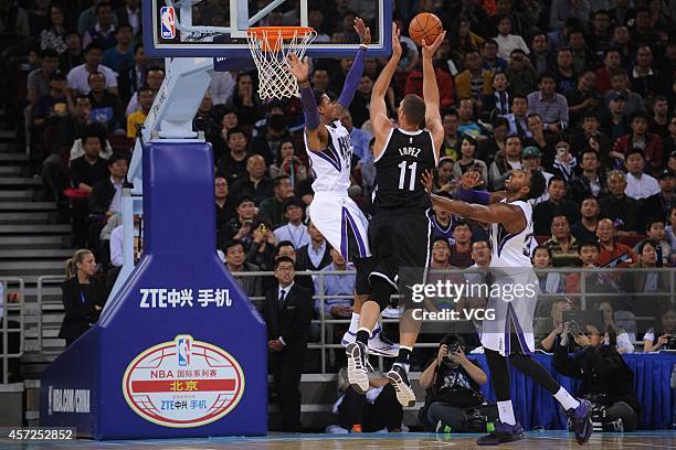 Brook Lopez of the Brooklyn Nets shoots against Ben McLemore and Jason Thompson of the Sacramento Kings during the game between the Brooklyn Nets and...